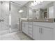 Bright bathroom featuring a double vanity and glass enclosed shower with marble tile and a built-in bench at 903 E 16Th St, Indianapolis, IN 46202
