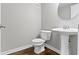 A half bathroom features gray walls, pedestal sink, modern fixtures, and wood-look tile flooring at 903 E 16Th St, Indianapolis, IN 46202