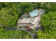 Bird's-eye view of the estate showing the landscaped grounds, pool, multiple outdoor living areas, and wooded lot at 9080 Pickwick Dr, Indianapolis, IN 46260