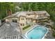 Aerial view of the house with a pool, patio area, well maintained landscaping, and wooded surroundings at 9080 Pickwick Dr, Indianapolis, IN 46260