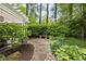 Beautiful, landscaped backyard patio with a walkway to a stone bench and planting beds at 9080 Pickwick Dr, Indianapolis, IN 46260