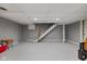 Unfinished basement with gray walls and floors featuring stairs to the main level at 9080 Pickwick Dr, Indianapolis, IN 46260