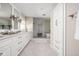 Bright bathroom featuring double vanity, shower, and storage cabinet at 9080 Pickwick Dr, Indianapolis, IN 46260