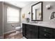 Well-lit bathroom with a dark vanity, white marble countertop, and neutral walls, showcasing classic fixtures and decor at 9080 Pickwick Dr, Indianapolis, IN 46260