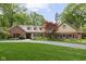 Beautifully landscaped home featuring a brick and siding exterior with a lush front lawn and mature trees at 9080 Pickwick Dr, Indianapolis, IN 46260