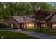 Charming brick home with a well-manicured lawn, mature trees, and a welcoming driveway at 9080 Pickwick Dr, Indianapolis, IN 46260