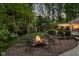 Backyard stone fire pit with seating area in a lush green setting, providing a serene outdoor space at 9080 Pickwick Dr, Indianapolis, IN 46260