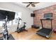 Home gym with brick accent wall, hardwood floors, and various exercise equipment at 9080 Pickwick Dr, Indianapolis, IN 46260