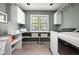 Functional laundry room with washer, dryer, storage cabinets, shelving, and a window for natural light at 9080 Pickwick Dr, Indianapolis, IN 46260