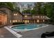 Exterior view of house from backyard with swimming pool, patio, and mature trees at 9080 Pickwick Dr, Indianapolis, IN 46260