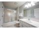 Bright bathroom featuring a tub with sliding glass doors, white vanity, and a large mirror at 9303 Aintree Dr, Indianapolis, IN 46250