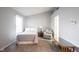 Comfortable bedroom featuring neutral colors, a double bed, floral chair, and carpeted flooring at 9303 Aintree Dr, Indianapolis, IN 46250