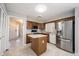 Bright kitchen with stainless steel appliances, wooden cabinets, and island with cream countertops at 9303 Aintree Dr, Indianapolis, IN 46250