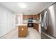 Well-lit kitchen with wood cabinets, stainless steel refrigerator, and island at 9303 Aintree Dr, Indianapolis, IN 46250