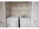 Washer and dryer inside of laundry closet with storage shelf and bi-fold doors at 9303 Aintree Dr, Indianapolis, IN 46250