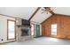 Bright living room features a stone fireplace, vaulted ceilings with beams, and large windows at 953 S 5Th St, Noblesville, IN 46060
