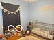 Well lit bedroom with blue walls, a crib, wood decor, and a black curtain at 1001 Maple W Dr, Lebanon, IN 46052