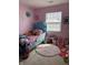 Pink bedroom featuring a blue bed, window, and colorful decor, creating a fun and playful space at 1001 Maple W Dr, Lebanon, IN 46052