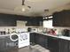A well-lit kitchen features dark cabinetry, tile flooring, and essential modern appliances at 1001 Maple W Dr, Lebanon, IN 46052