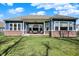 Backyard featuring a covered patio, lush lawn, brick accents, and a cozy seating area at 11072 Song Creek Ct, Fishers, IN 46040