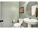 Charming half bathroom features neutral walls, a white toilet and a pedestal sink with a framed mirror at 11072 Song Creek Ct, Fishers, IN 46040