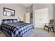 A cozy bedroom with a plaid bedspread, neutral walls, and a comfortable chair at 11072 Song Creek Ct, Fishers, IN 46040