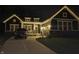 Charming home illuminated with decorative lights, enhancing its curb appeal in the evening at 11072 Song Creek Ct, Fishers, IN 46040