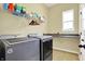 Functional laundry room features modern washer and dryer units with a countertop space at 11072 Song Creek Ct, Fishers, IN 46040