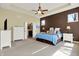 Spacious main bedroom with a tray ceiling, fan, carpeting and adjoining bathroom at 11072 Song Creek Ct, Fishers, IN 46040
