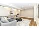 Cozy basement living area with a gray sofa, soft rug, and hardwood-look floors at 11505 Langton Walk, Zionsville, IN 46077