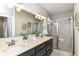 Modern bathroom featuring double sinks, a glass-enclosed shower, and neutral tile at 11505 Langton Walk, Zionsville, IN 46077