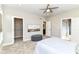 Neutral bedroom with carpet, modern ceiling fan, open doorways, and gray ottoman at 11505 Langton Walk, Zionsville, IN 46077