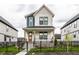 Charming two-story home with a covered front porch, black iron fence, and well-manicured landscaping at 11505 Langton Walk, Zionsville, IN 46077