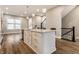 Kitchen with a large island, white cabinets, stainless steel appliances, and hardwood floors at 11505 Langton Walk, Zionsville, IN 46077