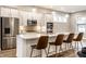 Modern kitchen with stainless steel appliances, white cabinets, and a large island with seating at 11505 Langton Walk, Zionsville, IN 46077