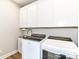 Efficient laundry room with modern washer, dryer, sink, and ample cabinet storage at 11505 Langton Walk, Zionsville, IN 46077
