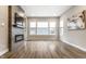 Living room with hardwood floors, fireplace with a tiled surround, and large windows with natural light at 11505 Langton Walk, Zionsville, IN 46077