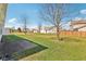 Spacious backyard with a large lawn, mature trees, and a view of neighboring homes at 1156 E Mill Run Blvd, Greenfield, IN 46140