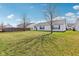 Backyard view featuring a green lawn, mature trees, and the house exterior at 1156 E Mill Run Blvd, Greenfield, IN 46140