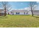 The house has a large yard with green grass and two large trees at 1156 E Mill Run Blvd, Greenfield, IN 46140