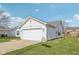 Well-maintained white home with attached two-car garage, lush green lawn and mature landscaping at 1156 E Mill Run Blvd, Greenfield, IN 46140
