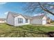 Side view of a well-maintained single-story home with white siding, blue shutters, and a lush green lawn at 1156 E Mill Run Blvd, Greenfield, IN 46140