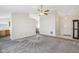 Open living room with neutral paint, plush carpeting, ceiling fan, and view to dining area and entry at 1156 E Mill Run Blvd, Greenfield, IN 46140
