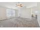 Spacious living room featuring plush carpeting, ceiling fan, large windows, and neutral paint at 1156 E Mill Run Blvd, Greenfield, IN 46140