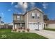 Charming two-story home with a well-maintained lawn and attached two-car garage at 11849 Wapiti Way, Noblesville, IN 46060
