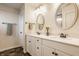 Well-lit bathroom with double vanity, oval mirrors, modern fixtures, and white cabinetry at 11925 Piney Glade Rd, Noblesville, IN 46060