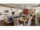 Open kitchen with a large island, seating, white cabinets, and view of dining area with rustic wooden table at 11925 Piney Glade Rd, Noblesville, IN 46060