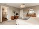 Bright main bedroom with access to bathroom, featuring a king bed, decorative pillows, chandelier, and bright windows at 11925 Piney Glade Rd, Noblesville, IN 46060