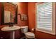 Stylish powder room with a pedestal sink, modern fixtures, and a framed mirror at 11925 Piney Glade Rd, Noblesville, IN 46060