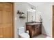 Clean bathroom featuring a granite countertop vanity, a toilet, and decorative floating shelves at 12129 N Cedarview Dr, Mooresville, IN 46158